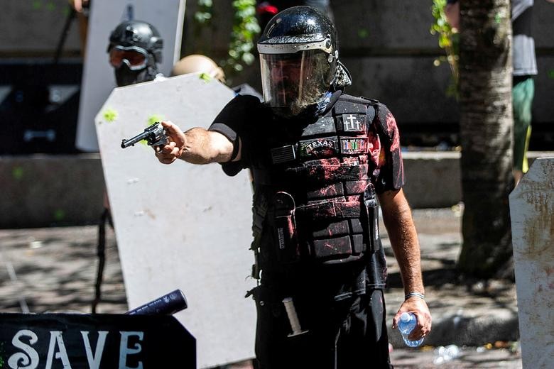 Alan Swinney points a gun during clashes between groups like Proud Boys and Patriot Prayer, and protesters against police brutality and racial injustice in Portland, Oregon. REUTERS/Maranie Staab  